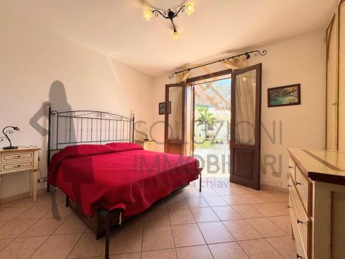 a bedroom with a bed with a red bedspread on it at Villa Calentana in Macari