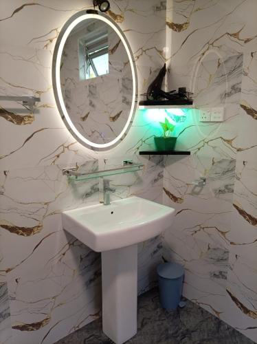 a bathroom with a sink and a mirror on a wall at Rainforest Nature Resort - Sinharaja in Deniyaya