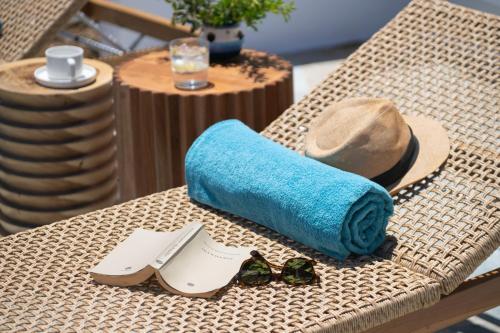 a table with a towel and a hat and sunglasses at Archipelago Sifnos - Seaside Accommodation in Vathi