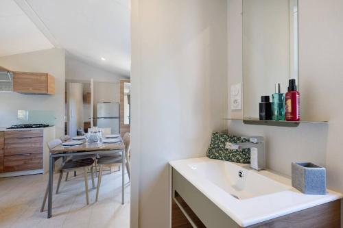 a kitchen with a sink and a dining table at Mobilehome Evasion 46 in Saint-Gervais