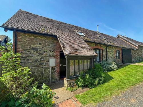 a small brick house with a grass yard at The Boyne Arms Cottage in Burwarton