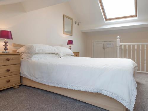 a bedroom with a large white bed and a window at Esthwaite in Windermere