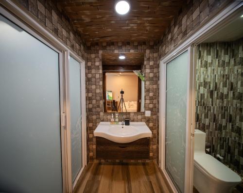 a bathroom with a sink and a mirror and a tub at Villa Crescenta in Ukulhas