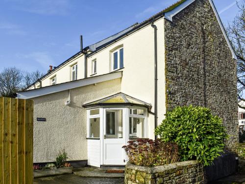 an old brick house with a white door at The Cottage - Uk35177 in Abbots Bickington