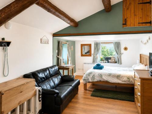 a living room with a bed and a couch at Bloomer's Bothy in Askrigg