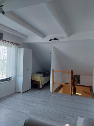 a attic room with a refrigerator and a bed at Mirni raj in Zlatar