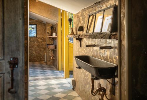 a bathroom with a sink on the wall at Tiny Wineyhouse 3 in Zennewijnen