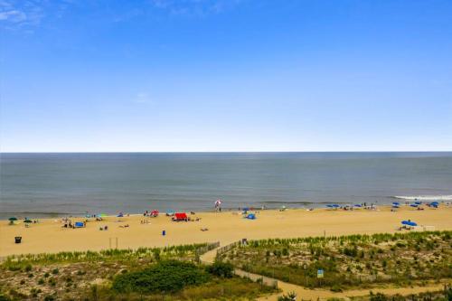 a beach with people and umbrellas and the ocean at Pyramid 4G in Ocean City