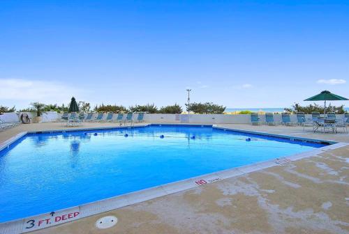 a large blue swimming pool with chairs and an umbrella at Pyramid 4G in Ocean City