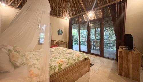 a bedroom with a bed with a mosquito net at Amara Giri Ubud View Villas in Ubud