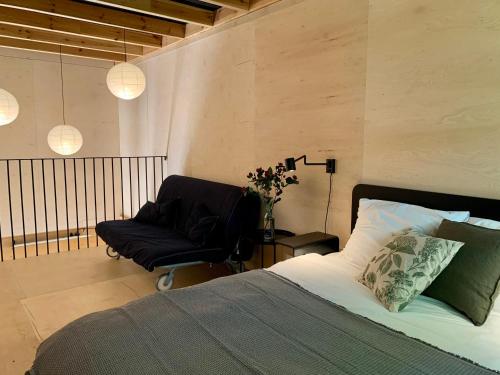 a bedroom with a bed and a chair and lights at Wyszumiane in Staniszów