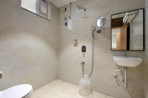a bathroom with a shower and a toilet and a sink at ELYSIUM Premier Suites Hitec City in Hyderabad