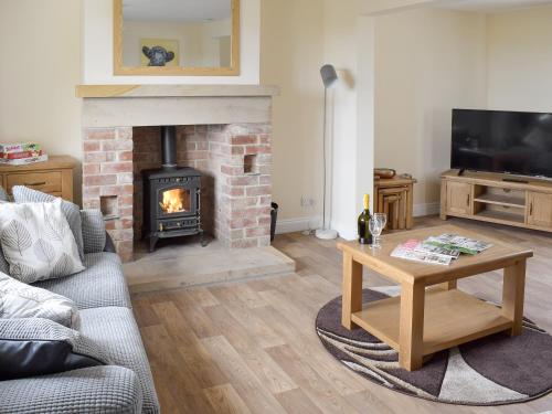 a living room with a couch and a fireplace at Rudda Farm House - Uk2491 in Staintondale