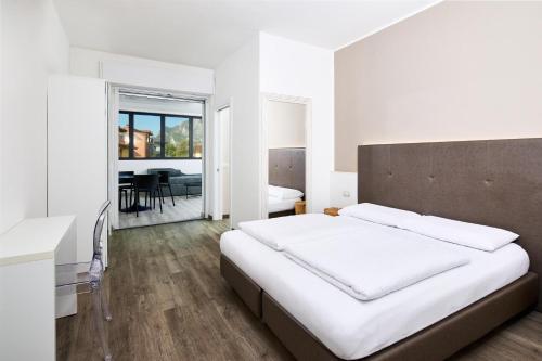 a bedroom with a large bed and a dining room at Rolly - Rooms & Restaurant in Riva del Garda