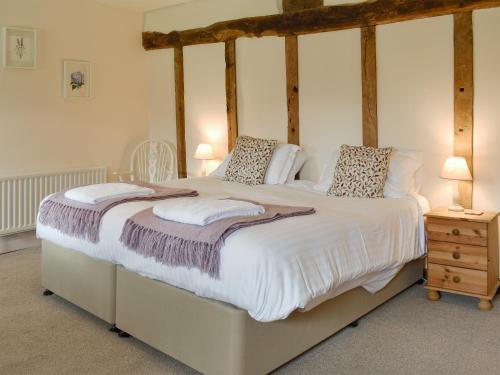 a bedroom with a four poster bed with white sheets at Churchill Cottage in Wootton Glanville