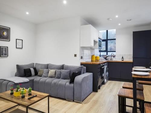 a living room with a gray couch and a kitchen at Green Mill 8 - Uk51369 in Holmfirth