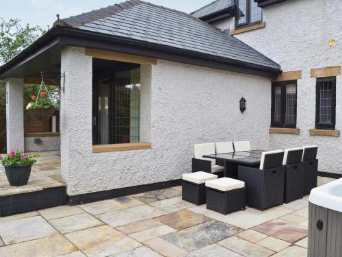 a patio with a table and chairs in front of a house at Castlebar in Little Singleton