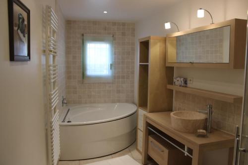 a bathroom with a large tub and a sink at La bastide in Vallauris