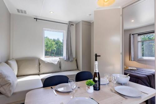 a living room with a table and a couch at Mobilehome Vallon 56 in Saint-Gervais