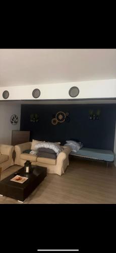 a living room with a couch and a table at Logement Bienvenue in Lallaing