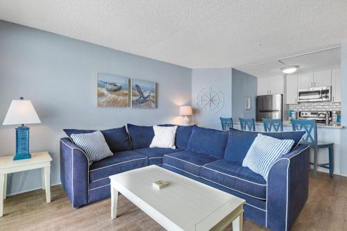 a living room with a blue couch and a kitchen at Pyramid 5C in Ocean City