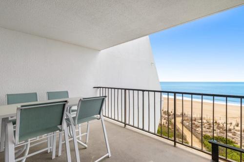 a balcony with a table and chairs and the beach at Pyramid 5C in Ocean City