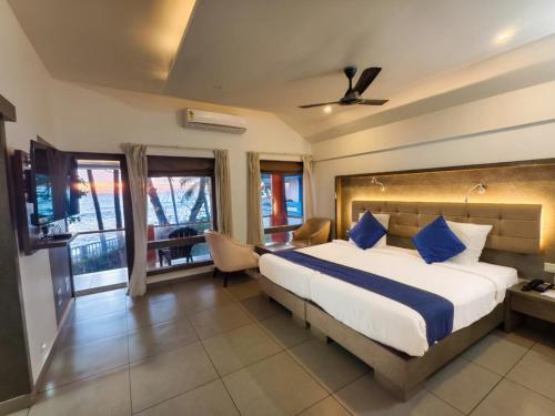 a bedroom with a large bed with blue pillows at Kappad Beach Resort in Kappad