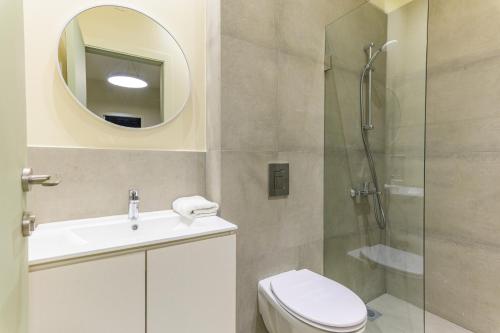 a bathroom with a shower and a toilet and a sink at Capri 2-BR Apartment In Bahsa Batroun in Batroûn