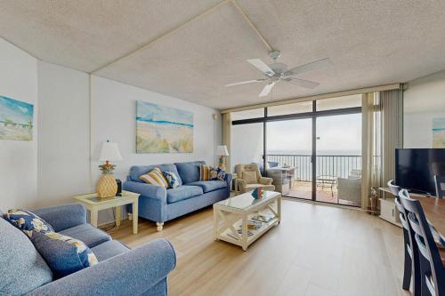 a living room with a blue couch and a tv at Pyramid 6K in Ocean City