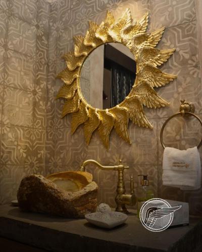 a bathroom with a gold mirror and a sink at Loft Michelle in Santeagueda