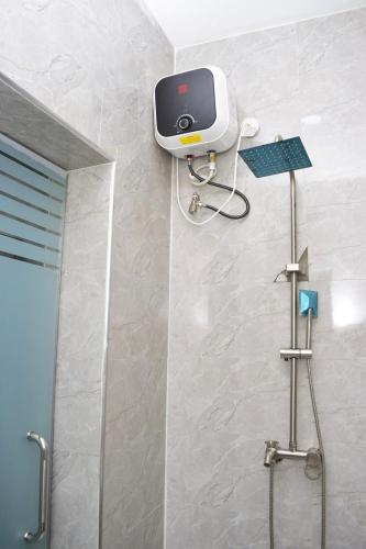 a shower with a scale on the wall of a bathroom at Welcome to Originclicks Apartments! in Ebute Ikorodu