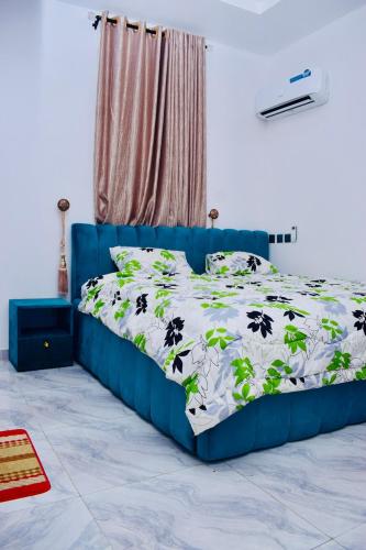 a blue bed with a black and white comforter at Welcome to Originclicks Apartments! in Ebute Ikorodu
