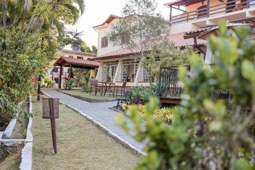 a house with tables and chairs in front of it at Hotel Santa Amalia in Vassouras