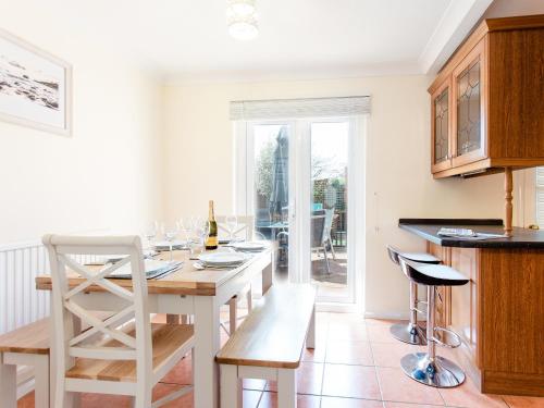 a kitchen with a table with a bottle of wine at Peacehaven in Shalfleet