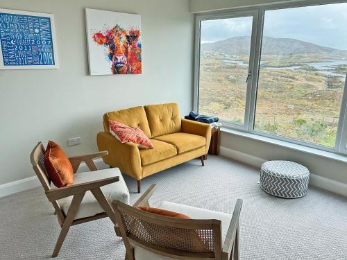 a living room with a couch and chairs and a window at Grianan in Eriskay