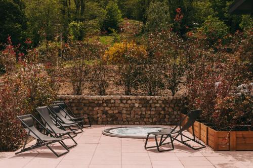 a group of chairs sitting around a pool in a garden at Estrela Serenity - Mountain Resort in Folgosinho