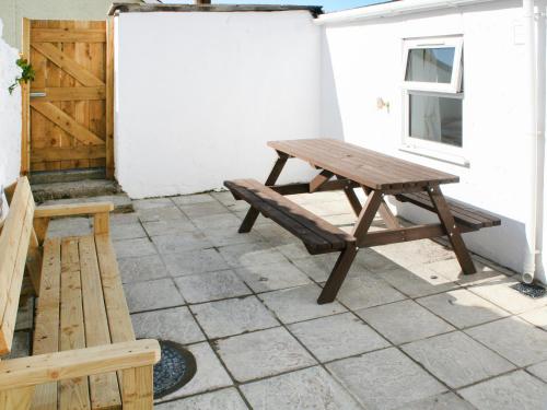 a picnic table and bench on a patio at Glan Y Mor - Uk52092 in Criccieth