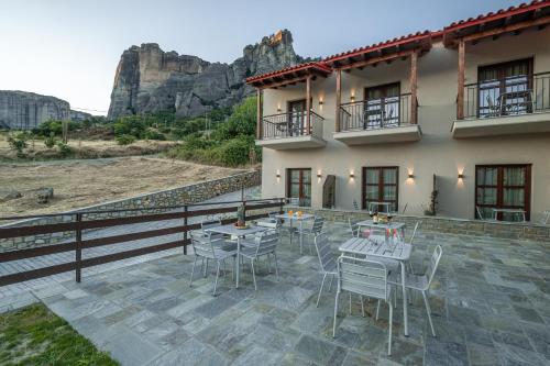 a patio with tables and chairs in front of a building at Terra Petra Meteora in Kalabaka