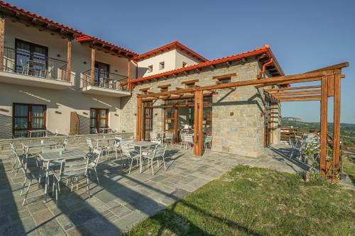 a patio with a table and chairs in front of a building at Terra Petra Meteora in Kalabaka