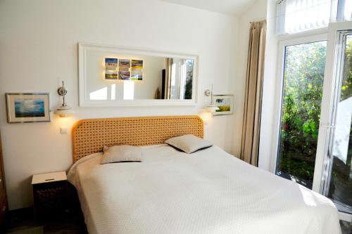a bedroom with a bed with a mirror and a window at Fliederuferhaus in Kosel