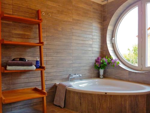 a bathroom with a large tub and a window at Fliederuferhaus in Kosel