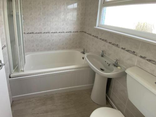 a bathroom with a tub and a sink and a toilet at Sea Pearl in Kessingland
