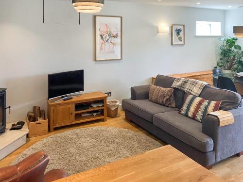 a living room with a couch and a television at Lower Mount Orchard in Stroud