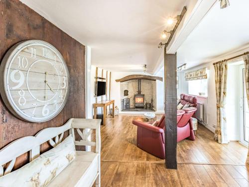 a living room with a large clock on the wall at Heath Hills in Okehampton