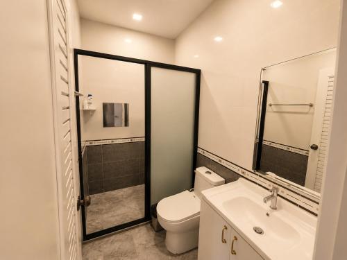 a bathroom with a toilet and a sink at Holi PTY Hotel in Ban Huai Yai