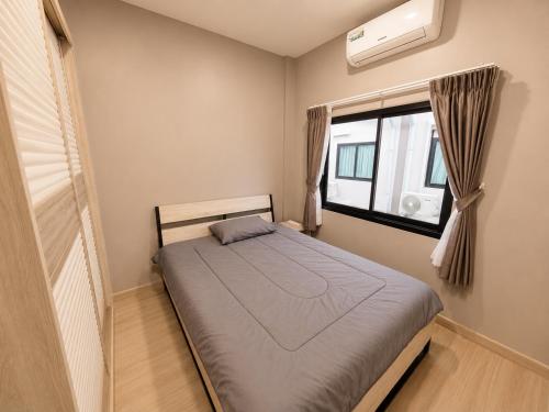 a small bedroom with a bed and a window at Holi PTY Hotel in Ban Huai Yai