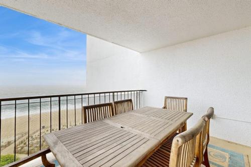 a balcony with a wooden table and a view of the beach at Pyramid 8K in Ocean City