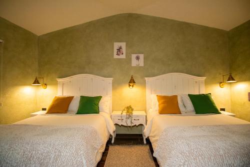 two beds in a room with green walls at Departamento Olivos 4 in Santeagueda