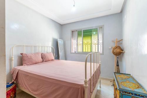 a bedroom with a pink bed and a window at Al manar in Oulad Akkou