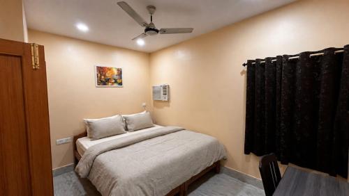 a bedroom with a bed and a ceiling fan at Ratnadeep Palace - Near Kashi Vishwanath Temple & Ghats in Varanasi